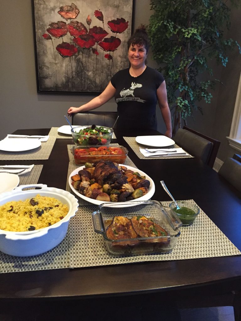 Woman posing with lots of different foods on a table in front of her