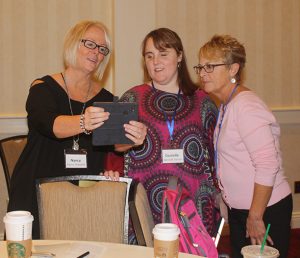 3 women looking at an iPad